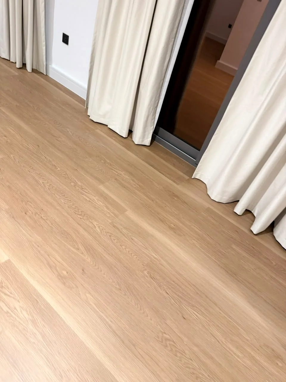SPC floor renovation meeting a glass door with white skirting, Aura Gardens Tilal Al Ghaf