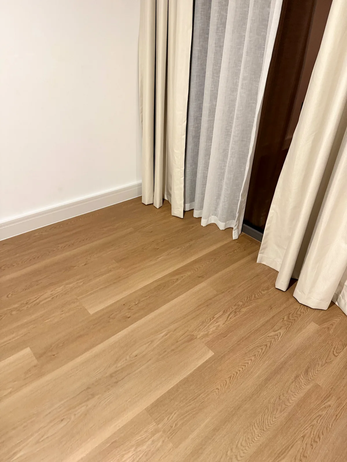 Light oak SPC planks with white skirting in Aura Gardens Tilal Al Ghaf villa flooring