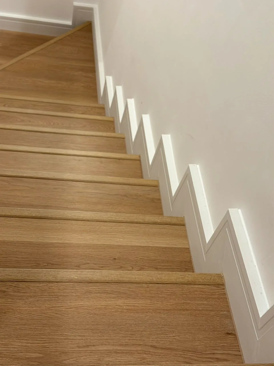 Top-down view of SPC stair cladding and white skirting, Tilal Al Ghaf flooring project