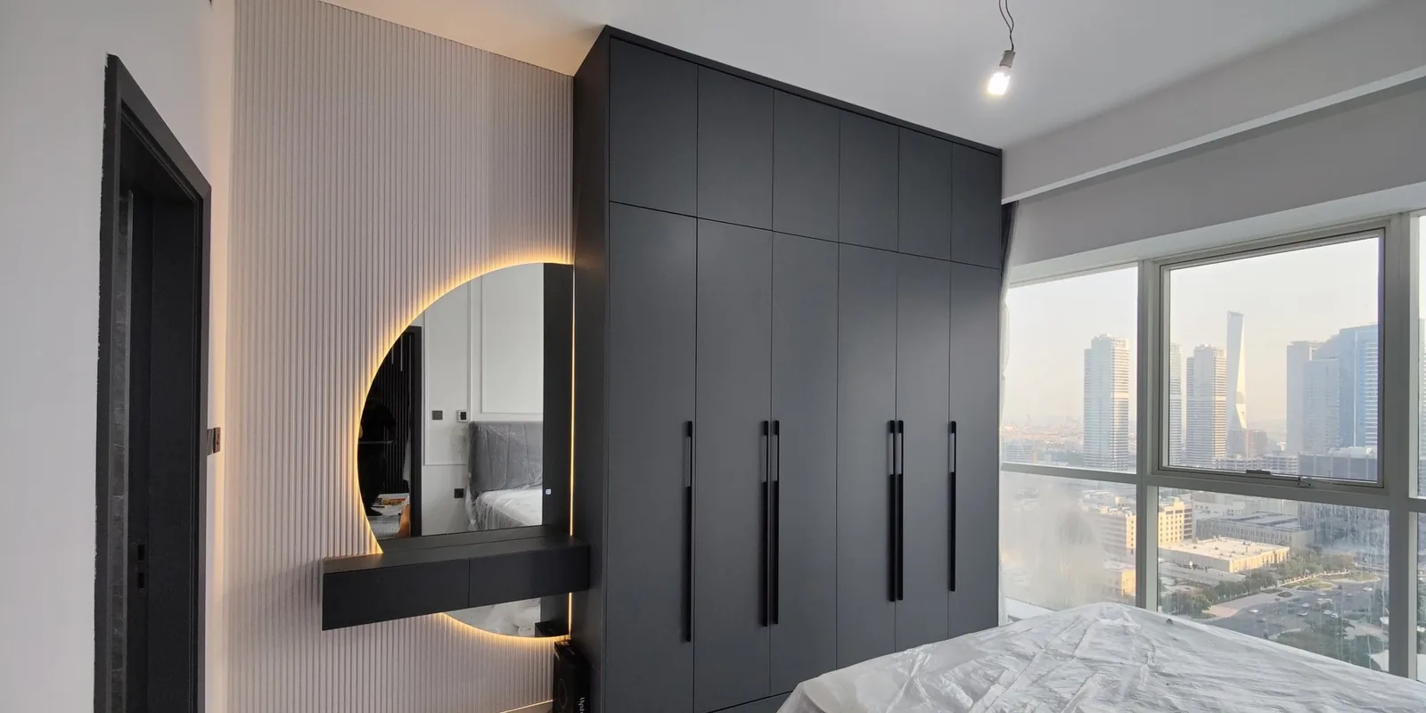 Black built-in wardrobe with round backlit mirror vanity
